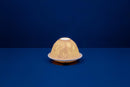 A white unglazed porcelain tealight holder with a dome cover, featuring a lithophane design that creates a golden pattern when lit from within.