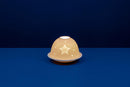 A white unglazed porcelain tealight holder with a dome cover featuring a lithophane star design, displayed against a blue background.